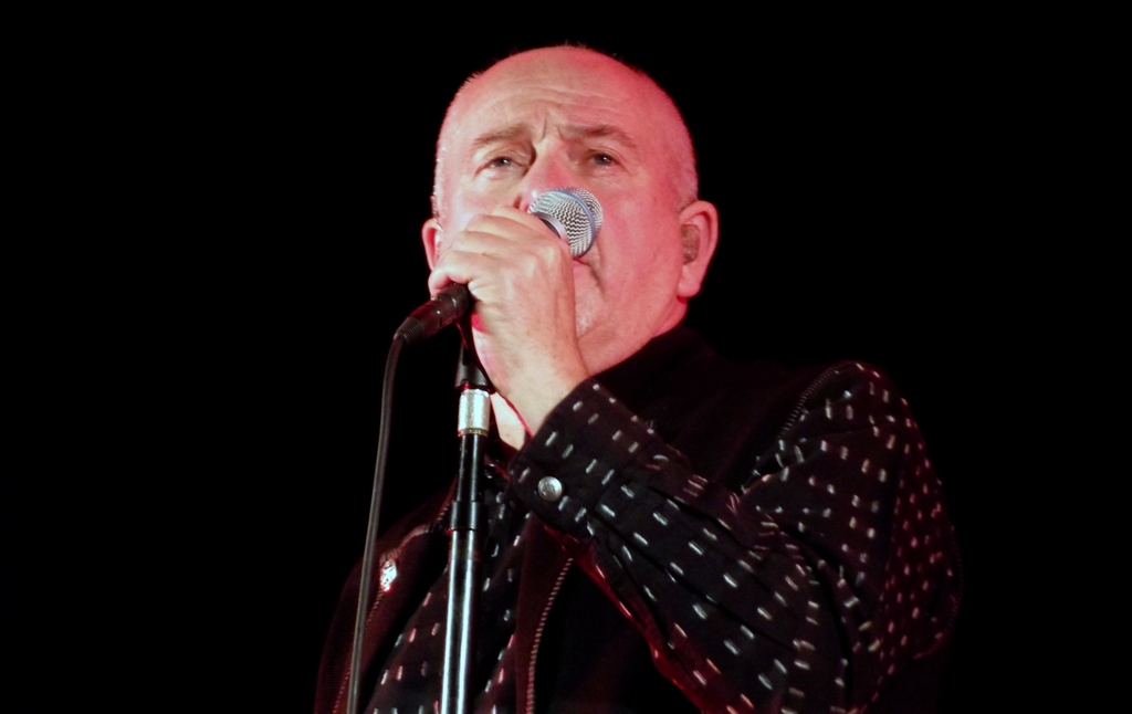 a man in black standing next to a microphone