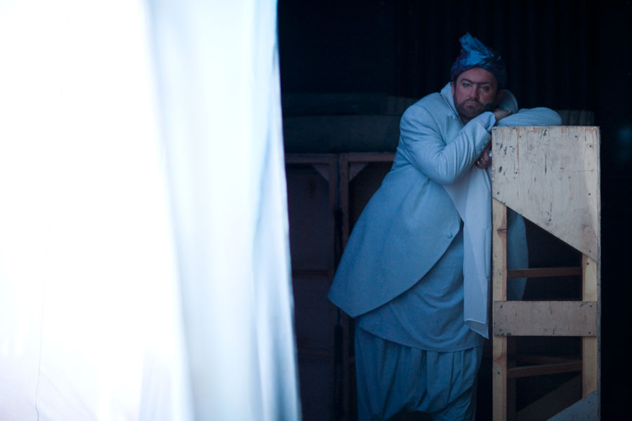 a man in white is standing behind a bunk bed