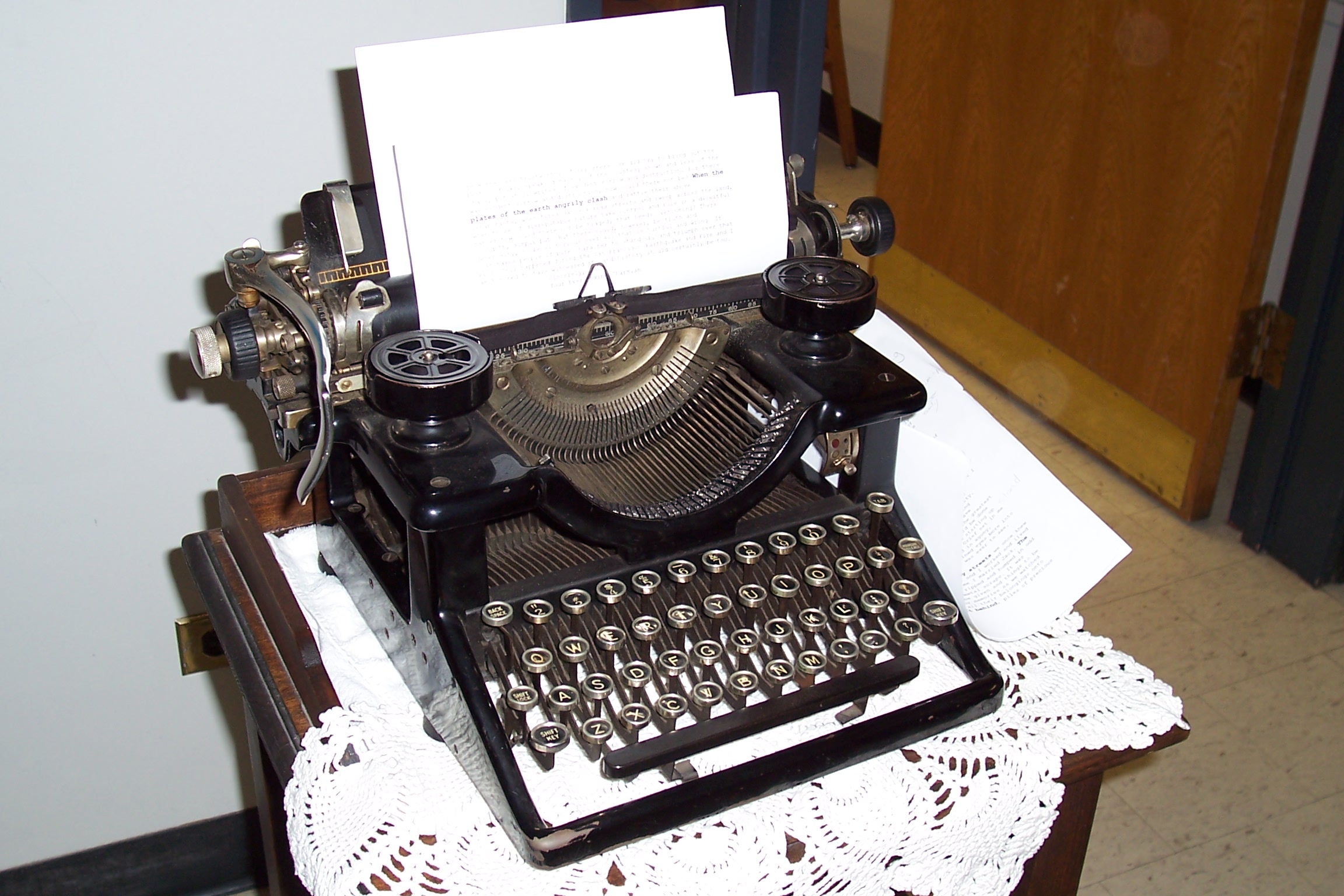 a black typewriter with papers and cards on it