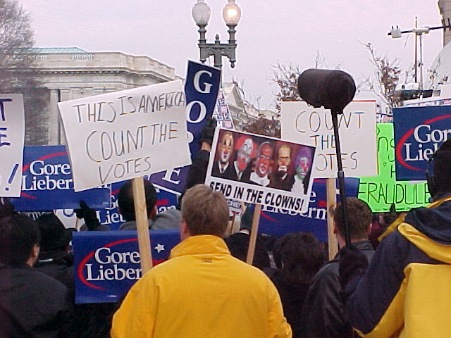 people in jackets and holding signs for presidential candidate
