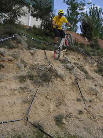 a person riding on top of a bike down a steep hill
