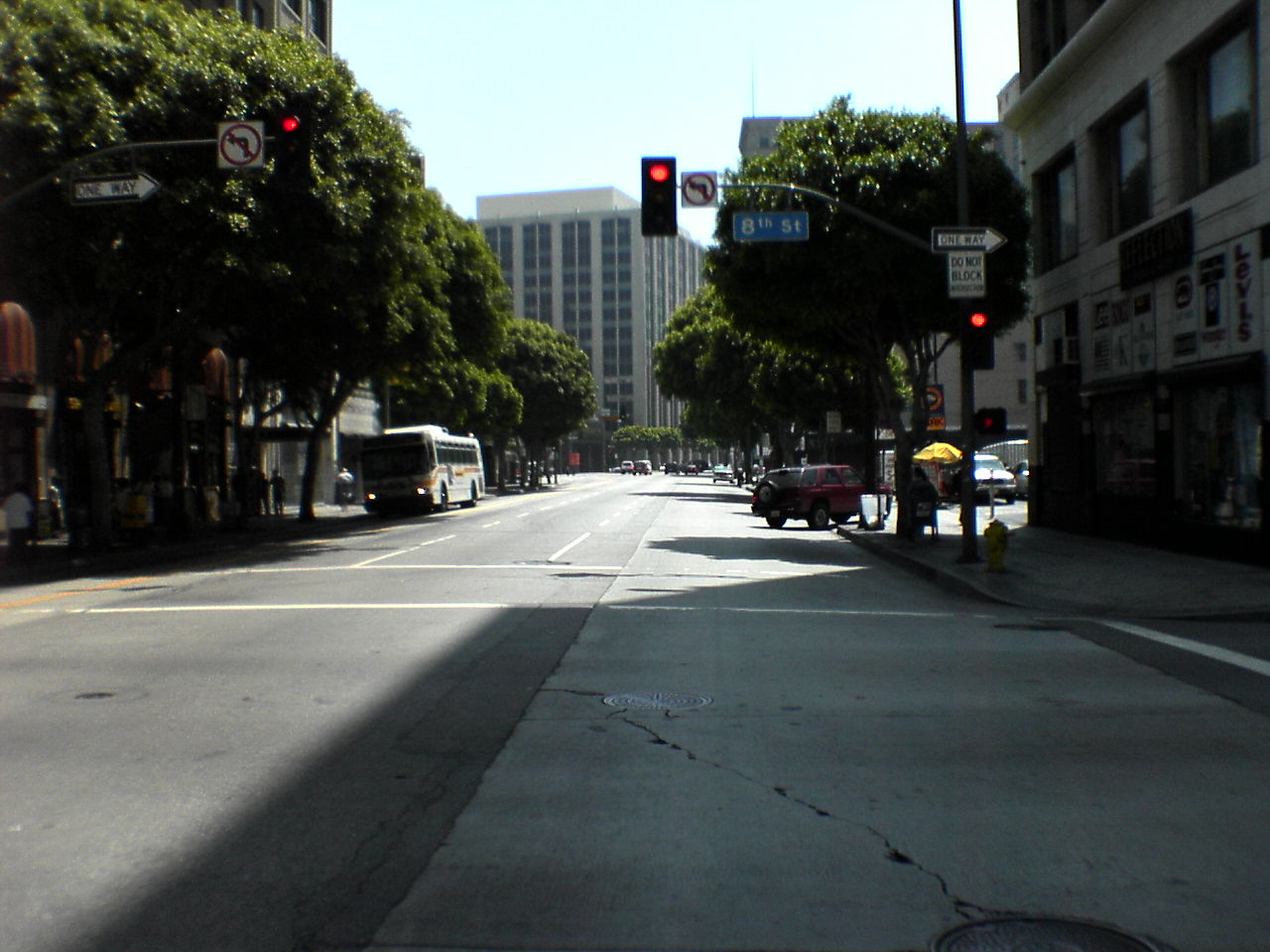 a view of a street with trees and traffic lights