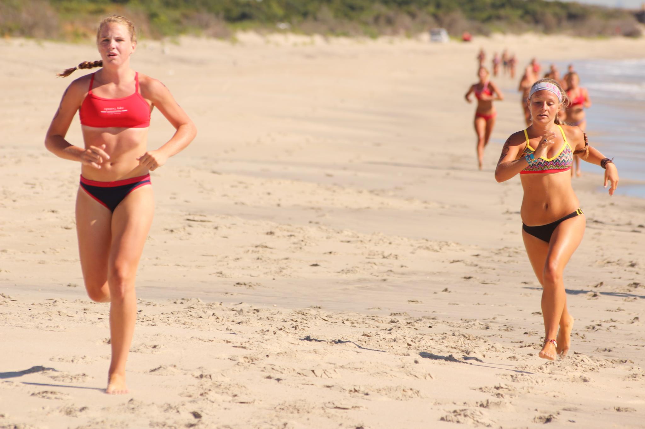 a couple of women that are standing on a beach