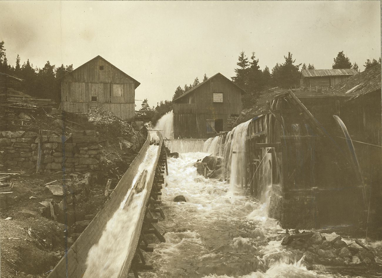 old pograph of water coming down from the side of a dam
