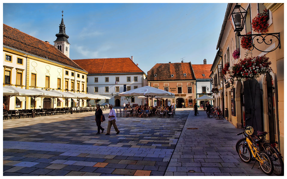 people are walking down the street at an outdoor market