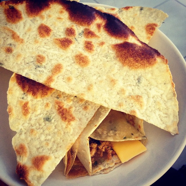 a white plate topped with tortilla and cheese