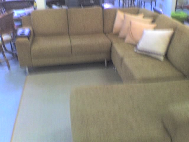 a big couch is sitting on a floor in a large room