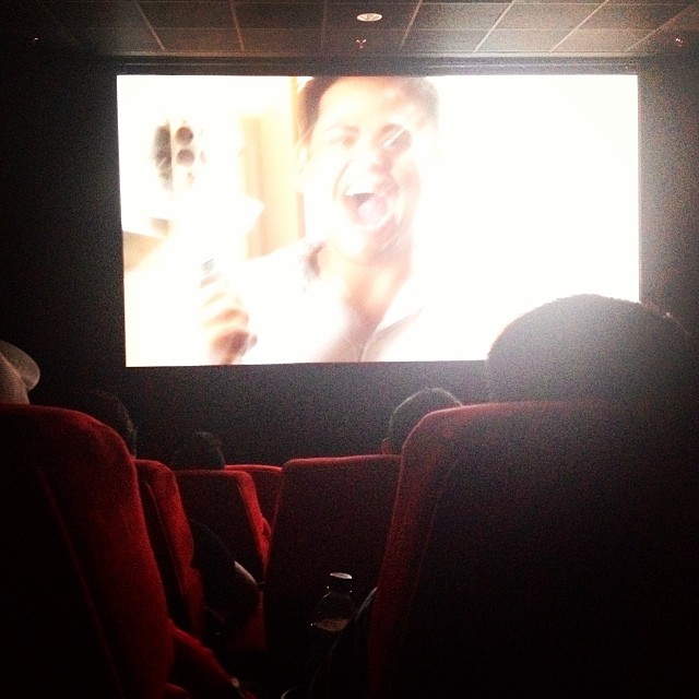 a man sitting in a movie theatre watching a movie