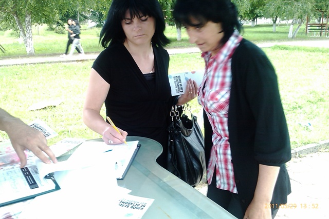 two women who are pointing to some papers