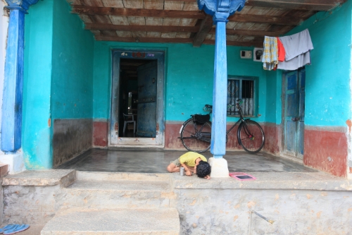 a man doing his face to the ground in front of a blue house