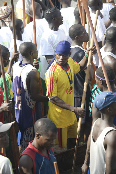 several men in colorful clothing gather around with stick in hand