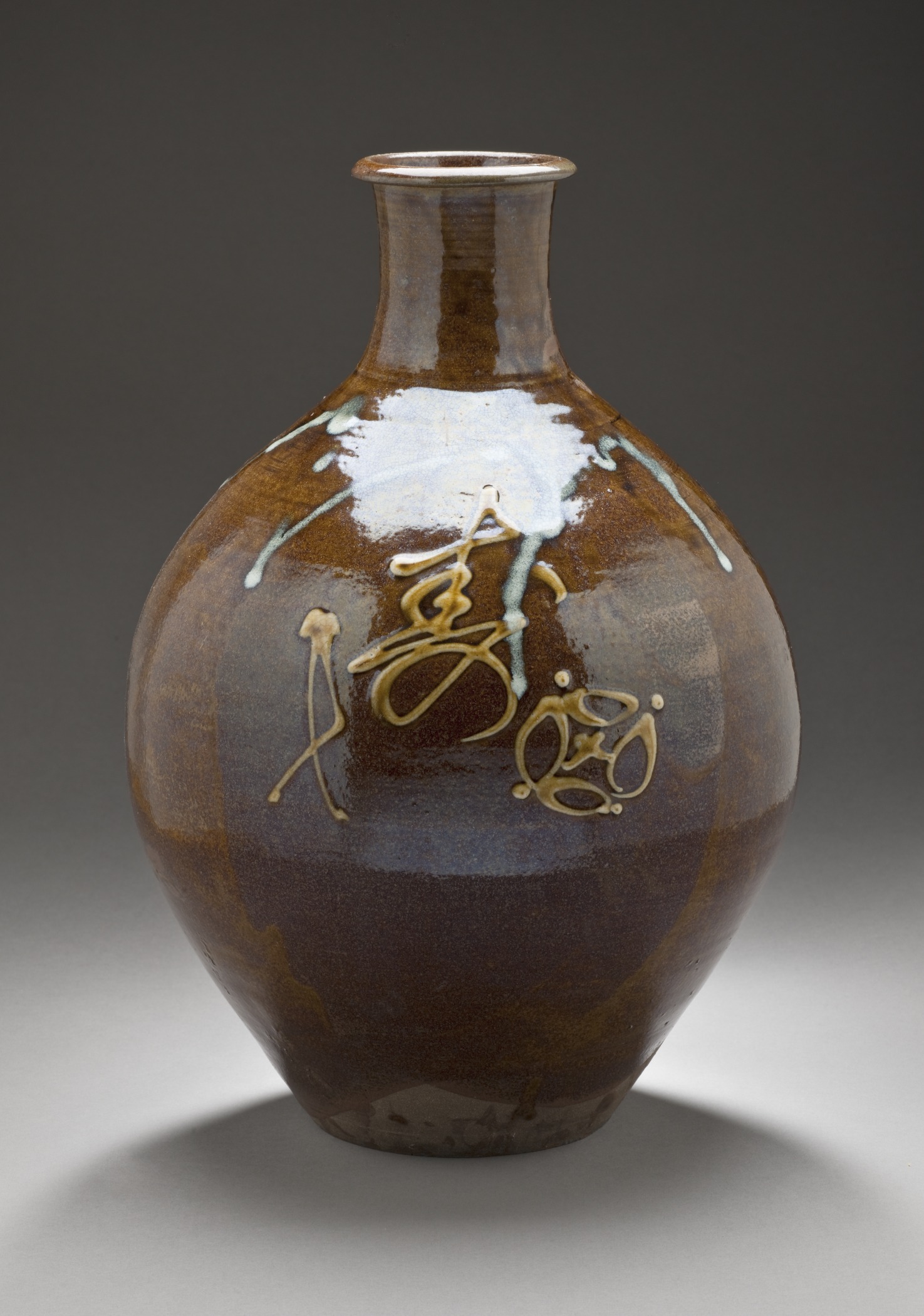 a small brown vase with a lot of gold ink on the outside of it