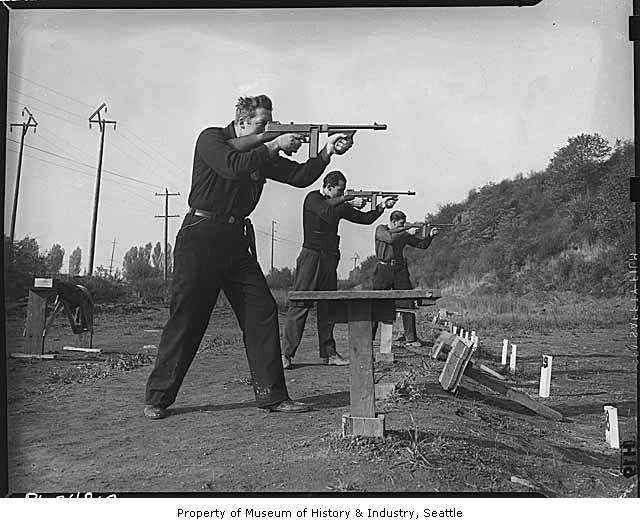 a group of men holding guns near a bench