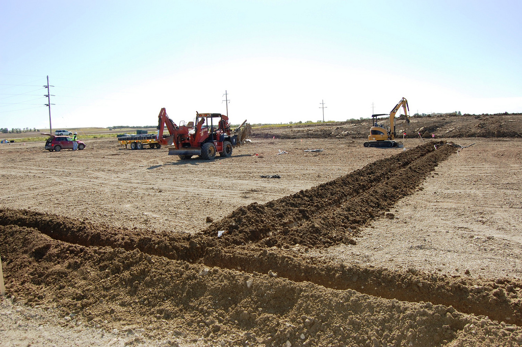 construction equipment in an open area next to a river