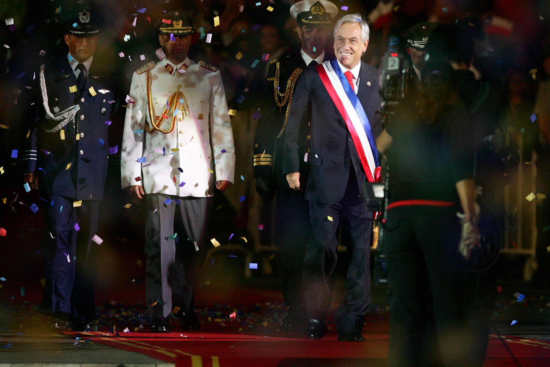 the president walks between military members and confetti thrown by them