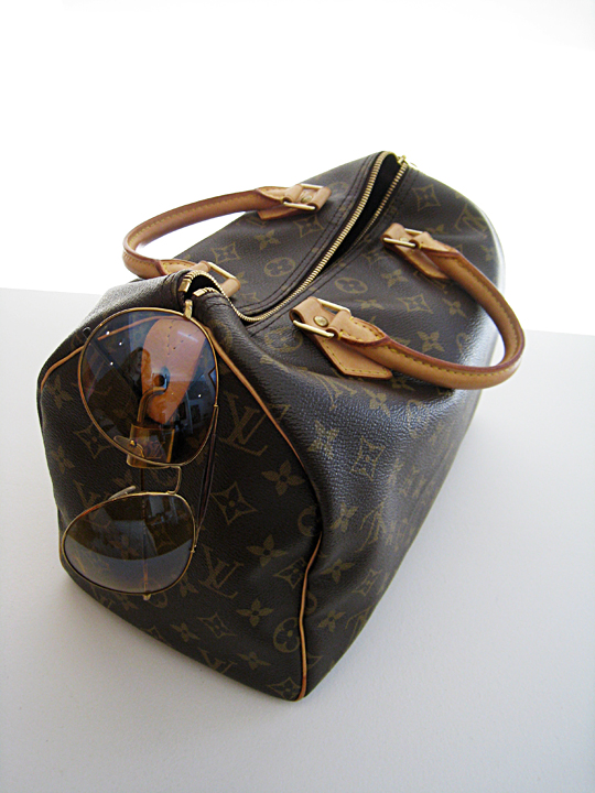 an old louis vuitton bag with sunglasses