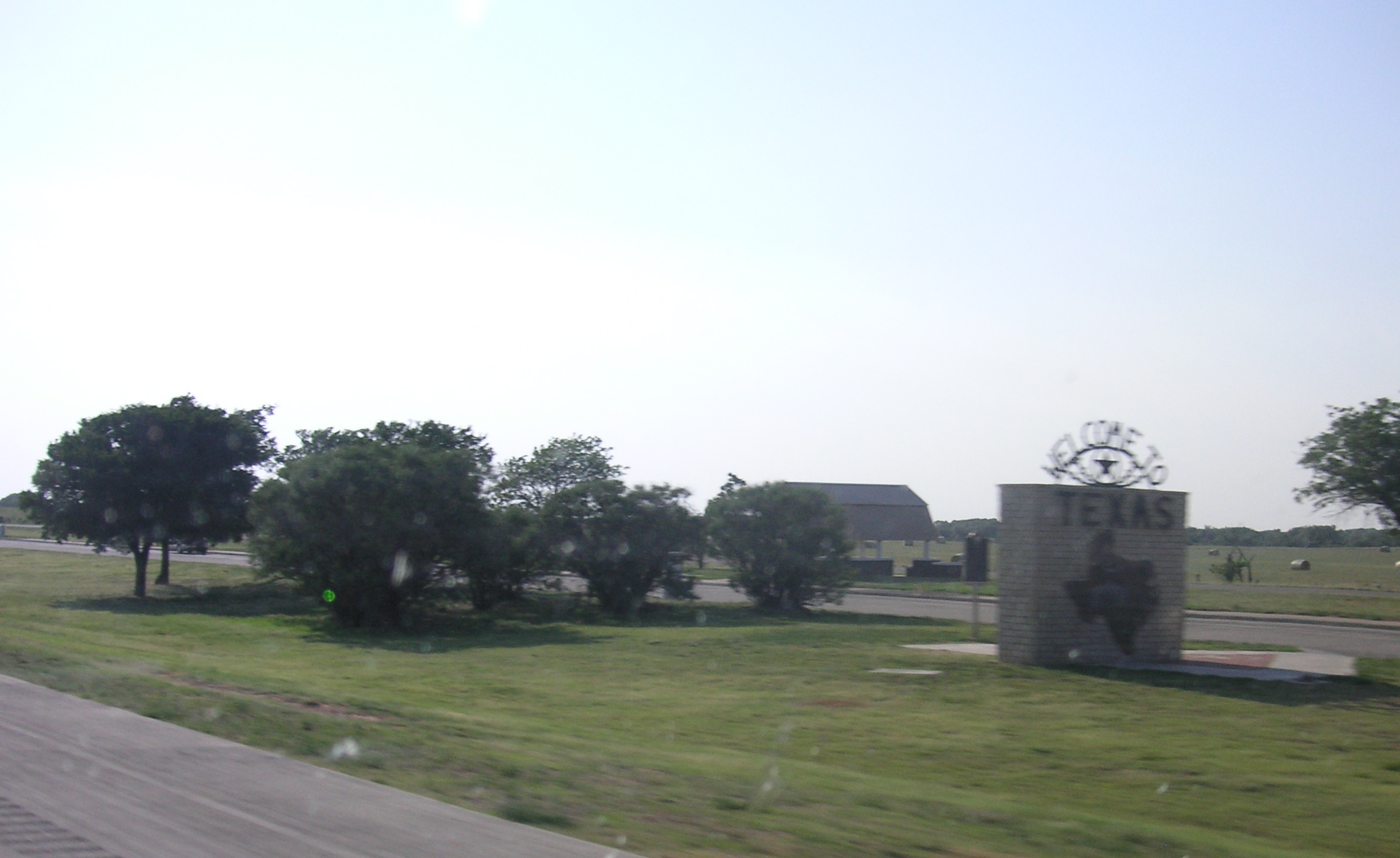 a grass yard in front of a small church and clock tower