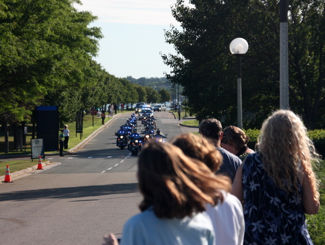 the motorcycle procession is on the road in front of a line of motorcyclist