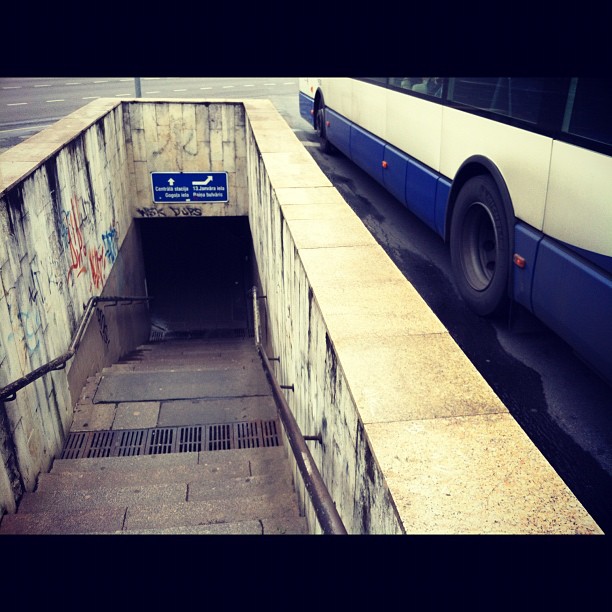 a bus entering a dirty tunnel with graffiti