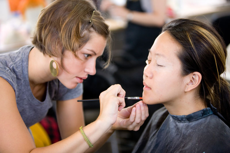two women doing make up at a hair salon