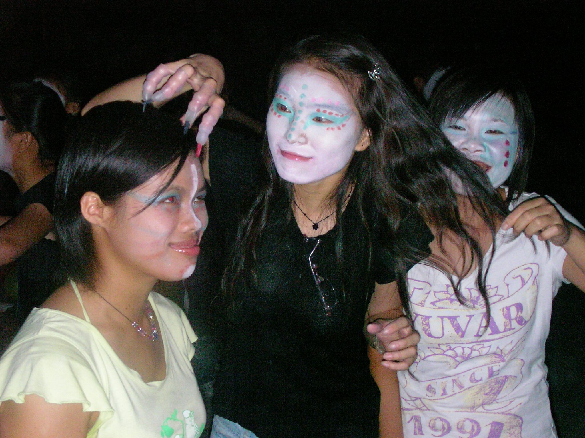 a group of girls in face paint looking at soing