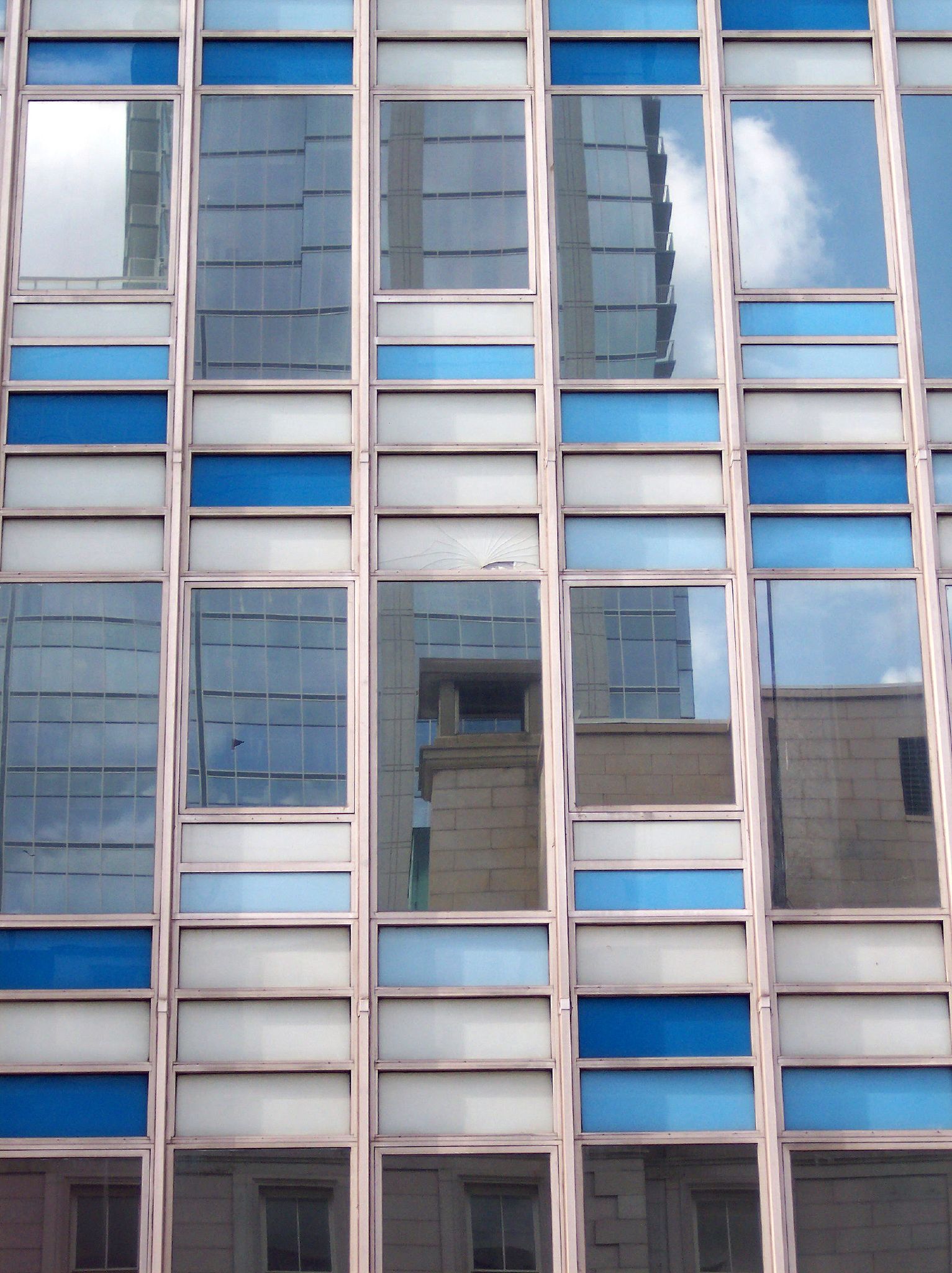 a very tall building with some windows reflected in it