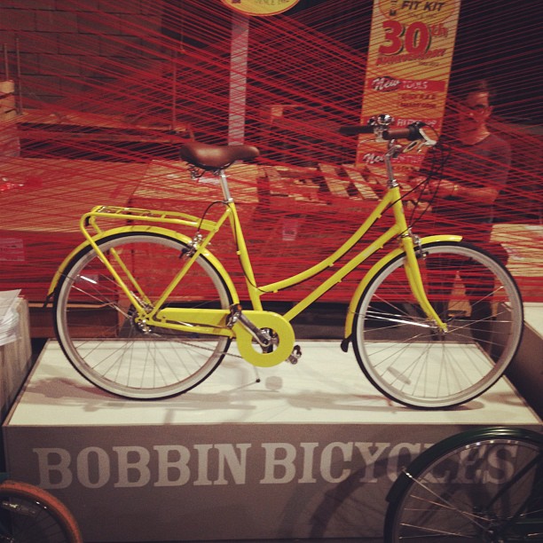 a yellow bike is on display in the window