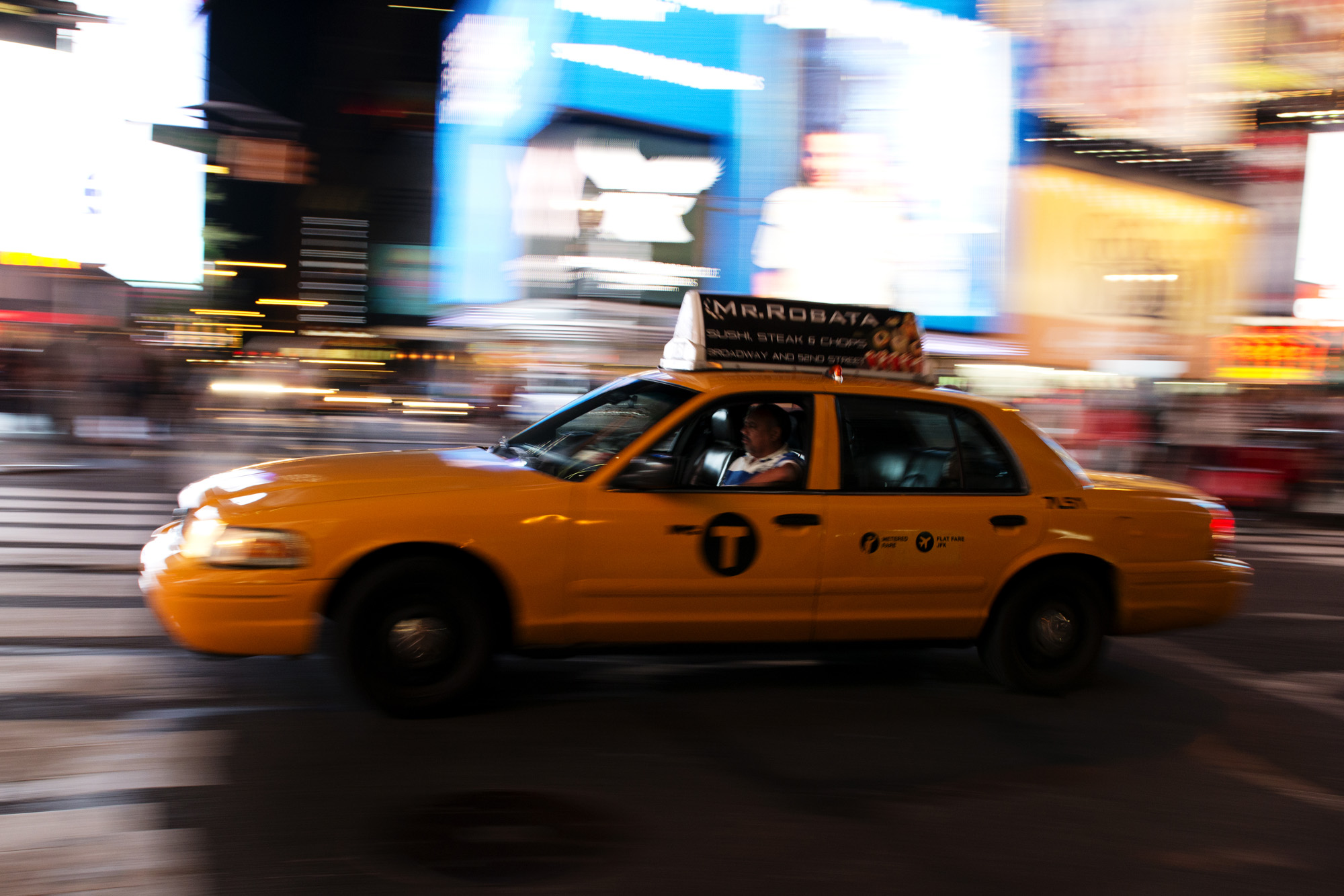 a taxi cab with a black top on a city street
