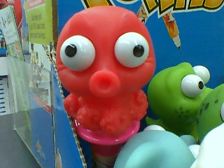 red toy with white eyes and black nose and green toy, with smaller one in front of it