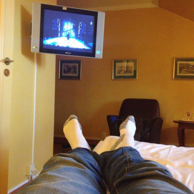 a person is laying down with their feet up in front of the television