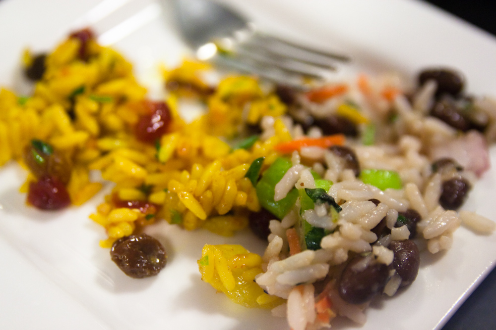 a plate of pasta with black olives and other food