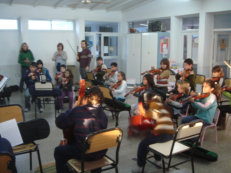 orchestra students and young children in an early school classroom