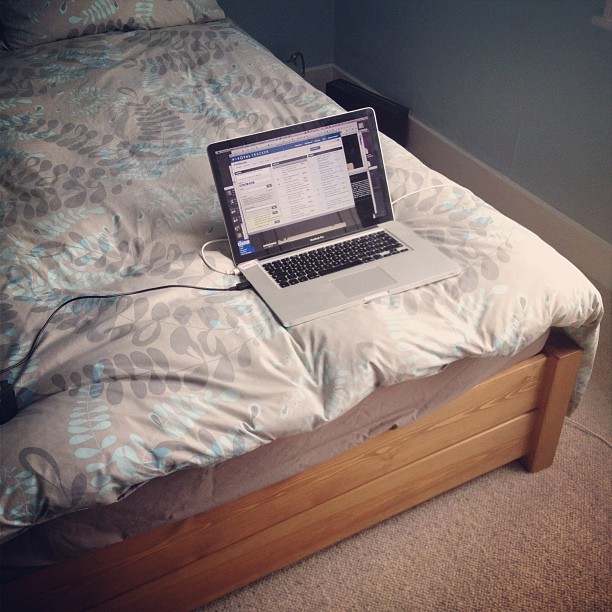 the laptop is sitting on a small bed