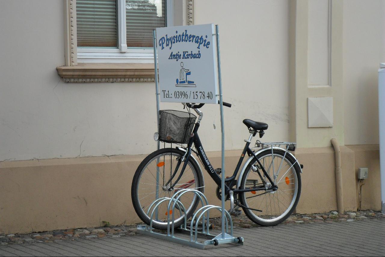 a bike parked on top of a stand in front of a building