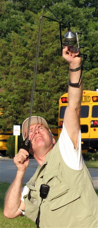 a man laying down and holding up a kite