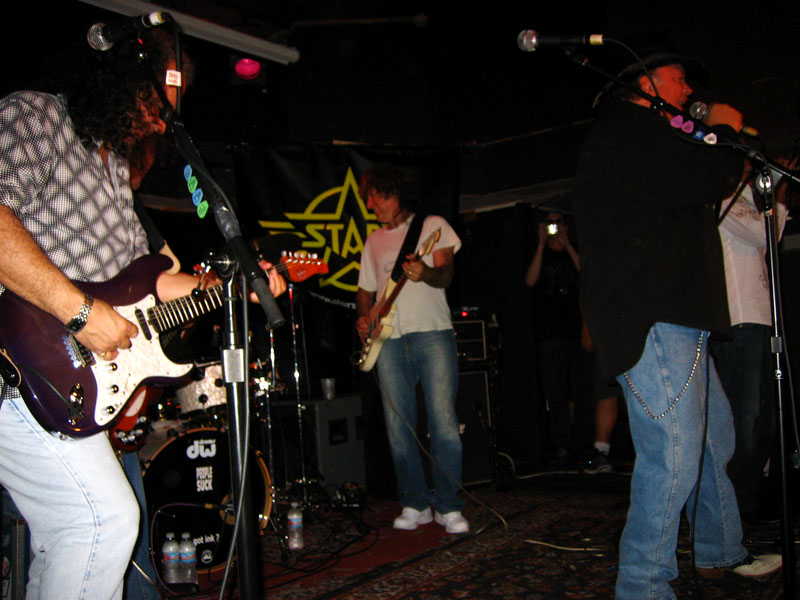 several men play music in the dark at the concert