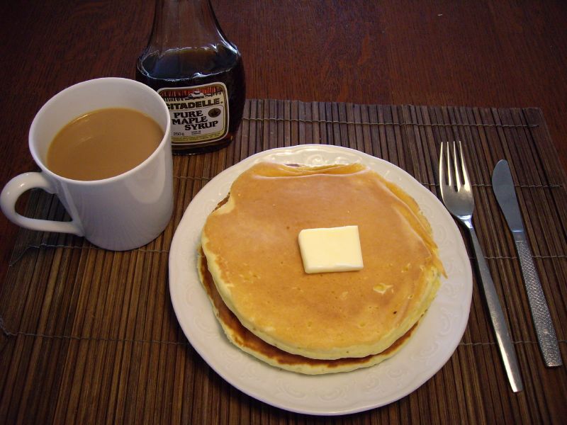 a plate with some pancakes and a cup of coffee