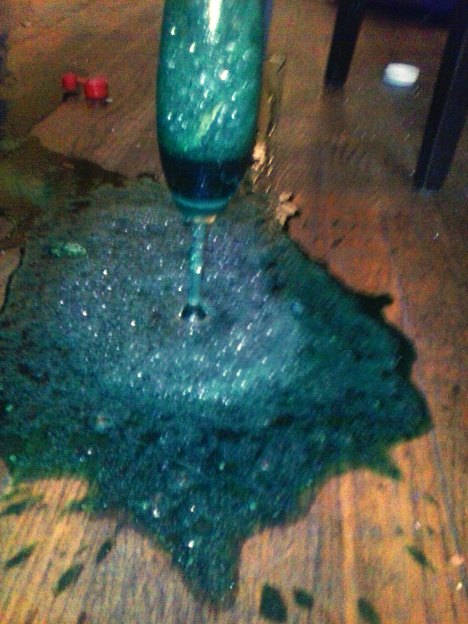 the vase is sitting on the ground, leaking liquid