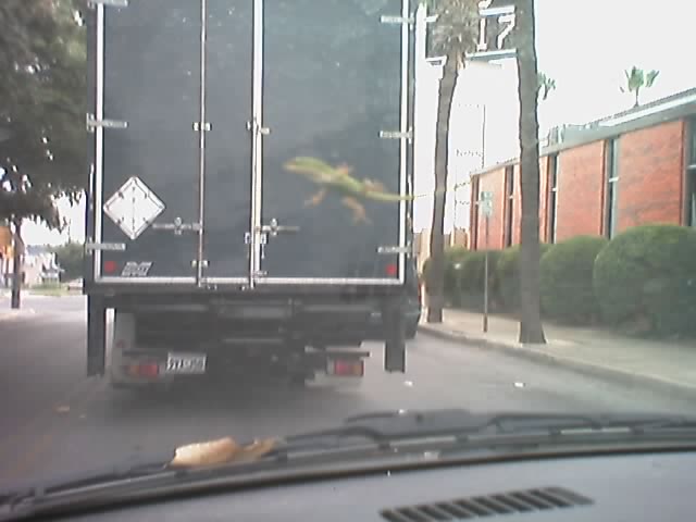 a truck with it's door open moving along a road