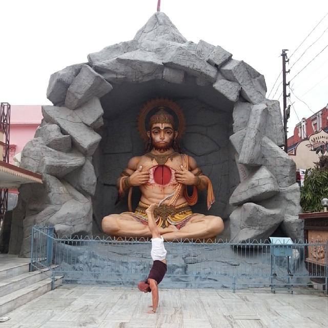 a person does yoga in front of a statue