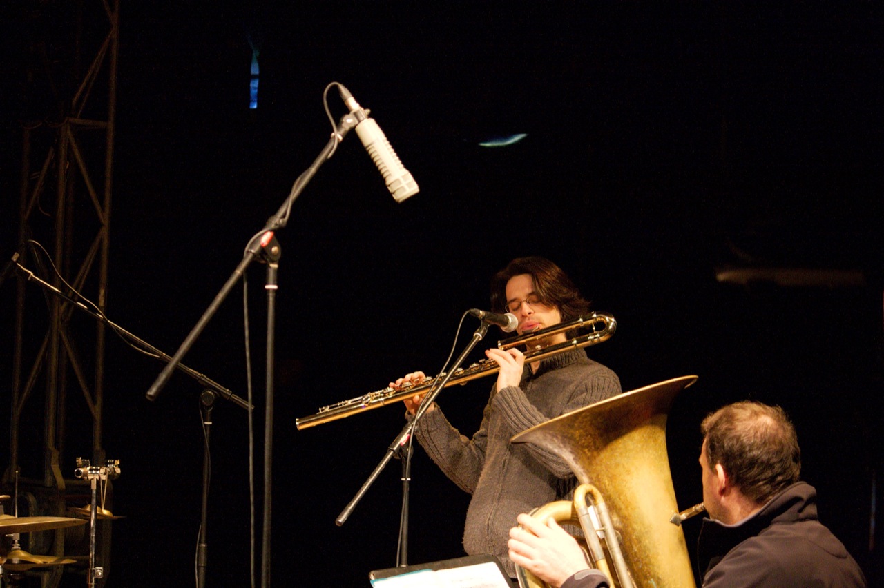 a man playing on a trombone during night