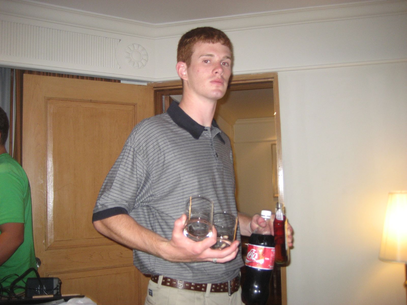 a young man holds two empty wine glasses