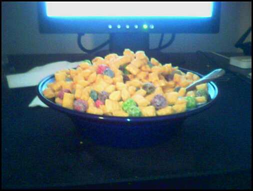 a bowl with cereal on it is sitting in front of a computer