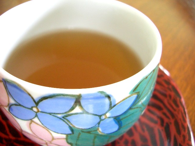 a cup of green tea with a blue flower pattern