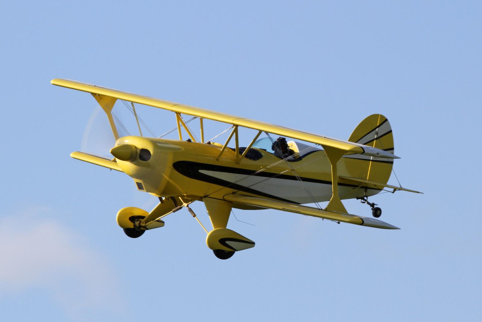 an antique biplane is flying in the sky