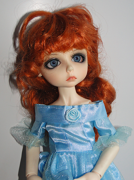 an orange haired doll wearing a blue dress