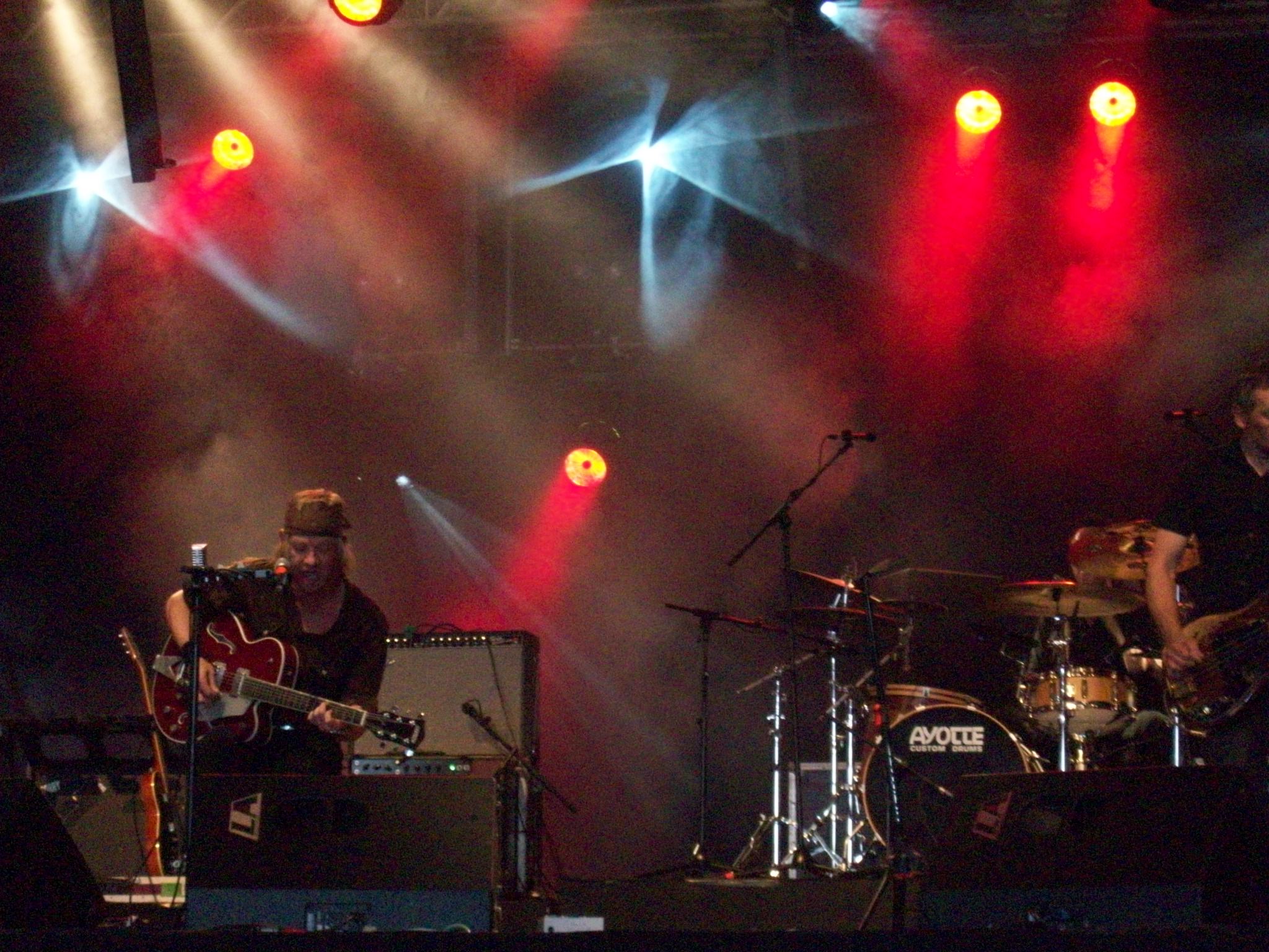 a band on stage playing music with red and blue lights