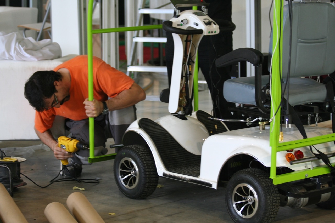 a man working on a small car with a lift