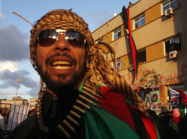 man wearing an dreadlocked hat and shades outside an apartment building