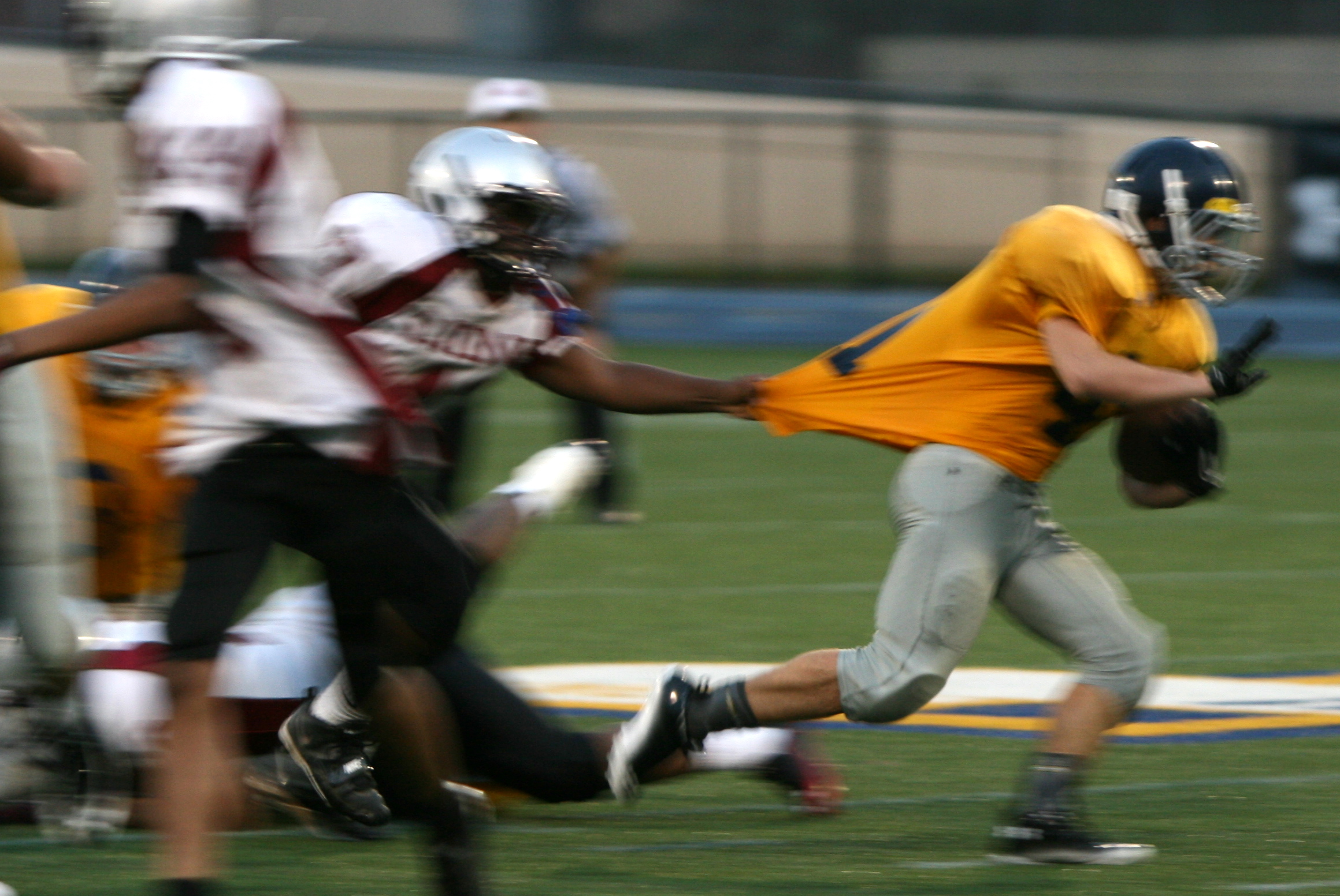 a group of football players running with the ball in the air